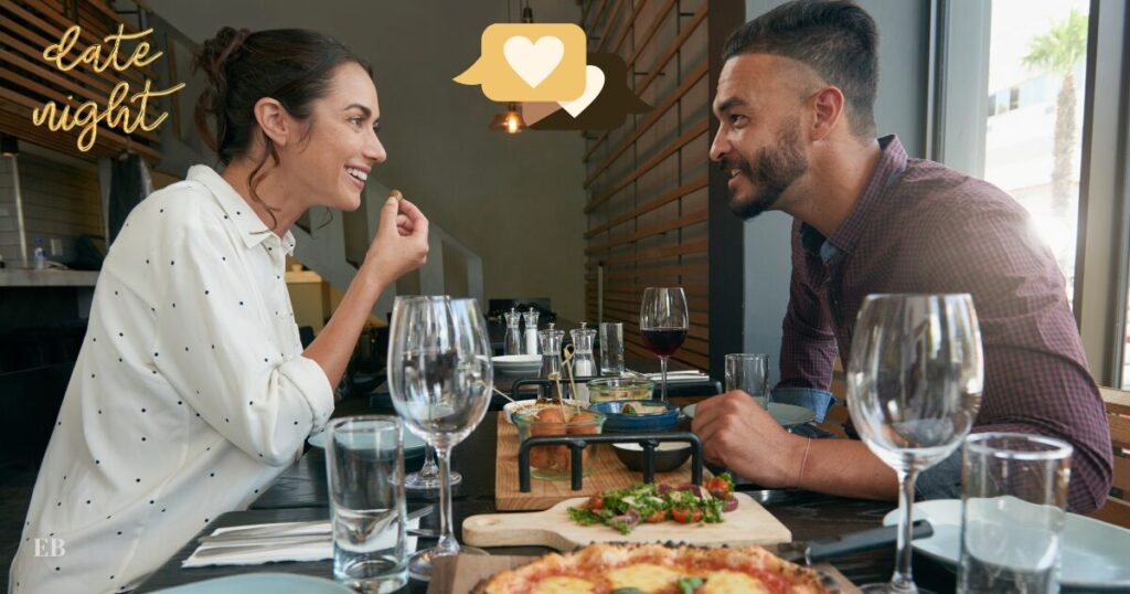A couple sitting at t table having a date and looking engaged.