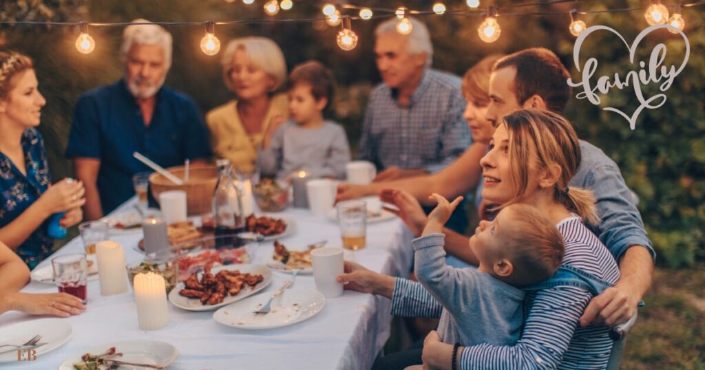 A extended family sitting and eating around a table in a garden
